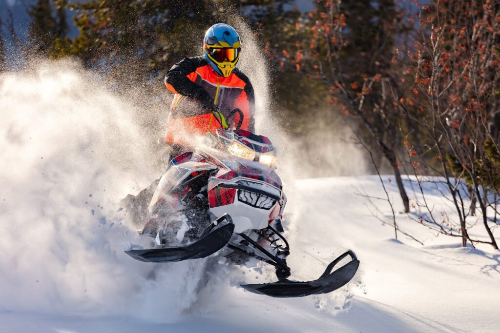 Snowmobile racing across a snowy winter landscape at high speed