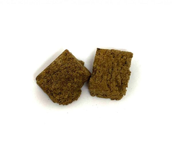 Pink Kush bubble hash compressed block with rich golden brown resin texture close up view