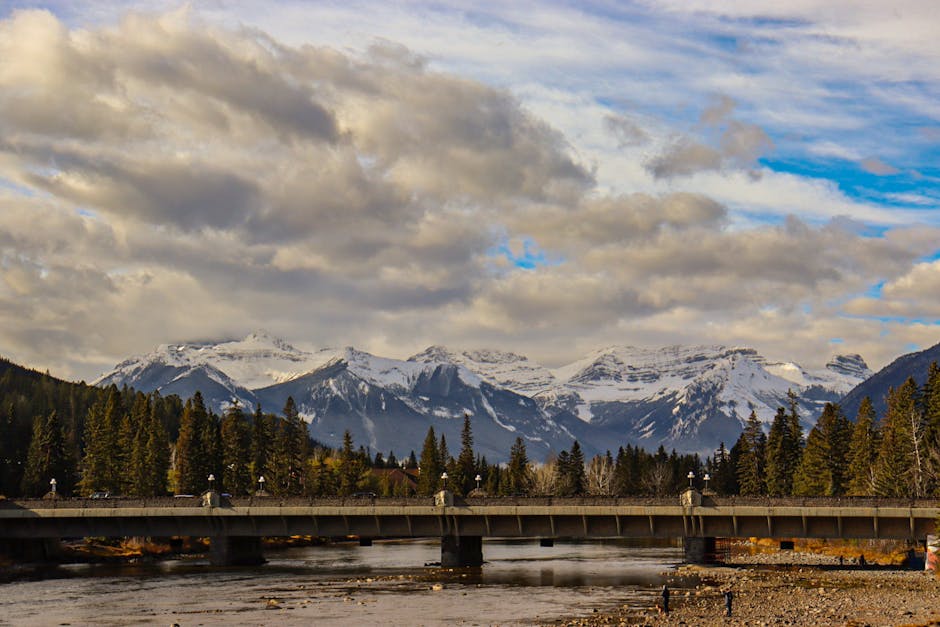 Stunning view of snow-capped mountains in Banff National Park, Alberta, Canada with a bridge in the foreground.