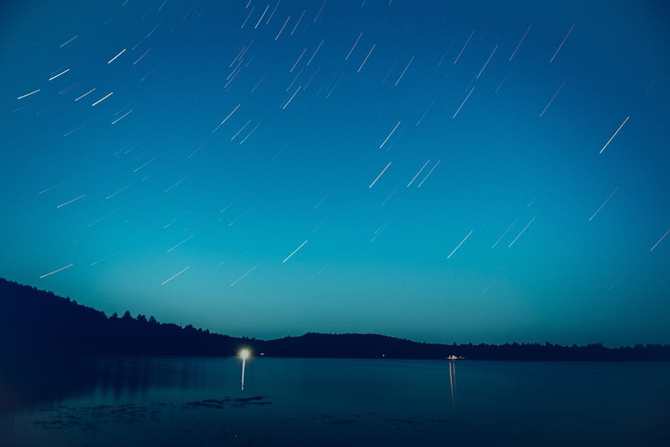 Long exposure of star trails over a lake in Barry's Bay, Canada, creating a serene night scene.