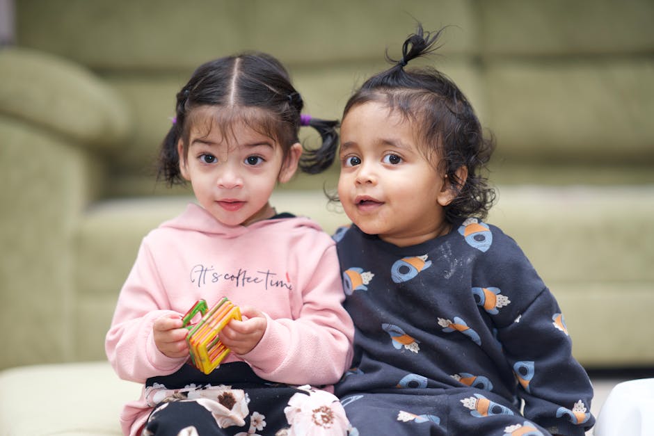 Cute kids enjoying playtime indoors with building blocks.