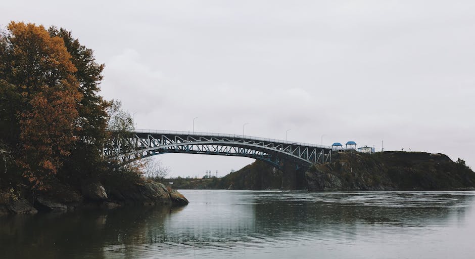 A scenic bridge in Saint John, NB, Canada with autumn foliage and calm river view.
