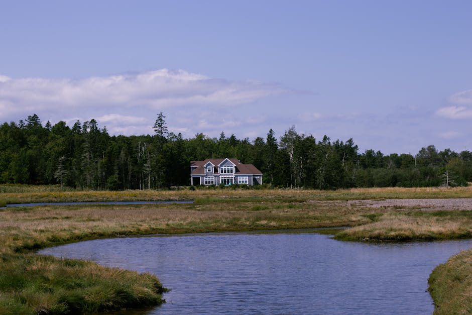 Charming rural landscape with a house by a meandering river in St. Andrews, Canada.