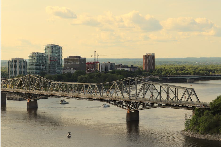 Aerial view of Alexandra Bridge spanning the Ottawa River, with Gatineau skyline in the background.
