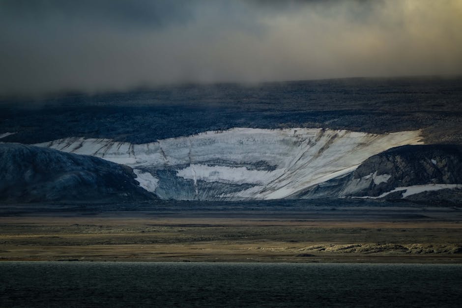 Moody Arctic scene showcasing a rugged glacier and dark storm clouds.