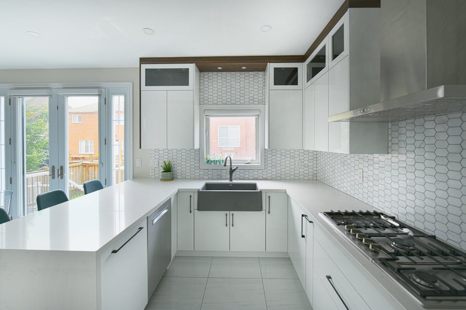Bright and spacious modern kitchen featuring a large island, farmhouse sink, and sleek cabinetry.