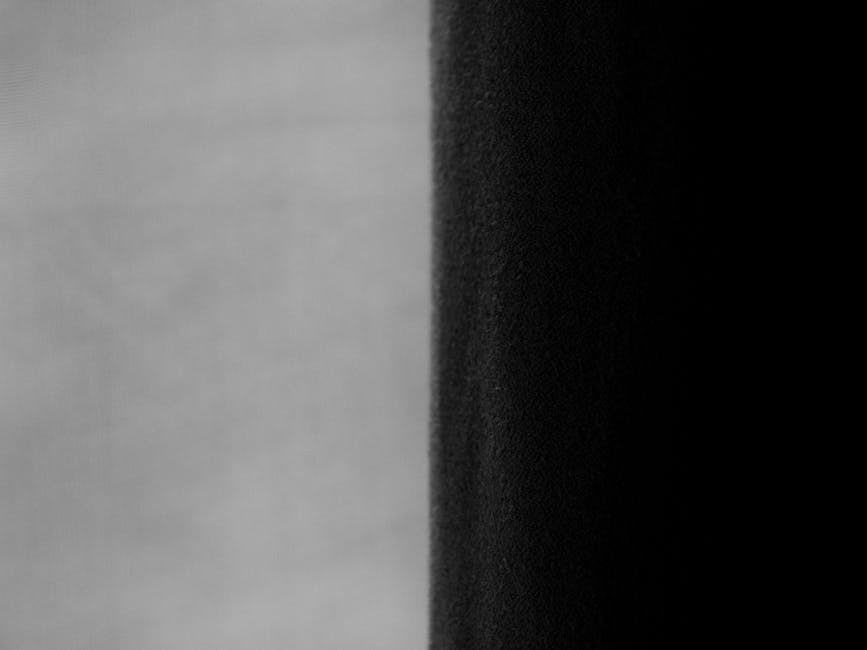 Close-up of contrasting greyscale drapes in a modern interior setting.