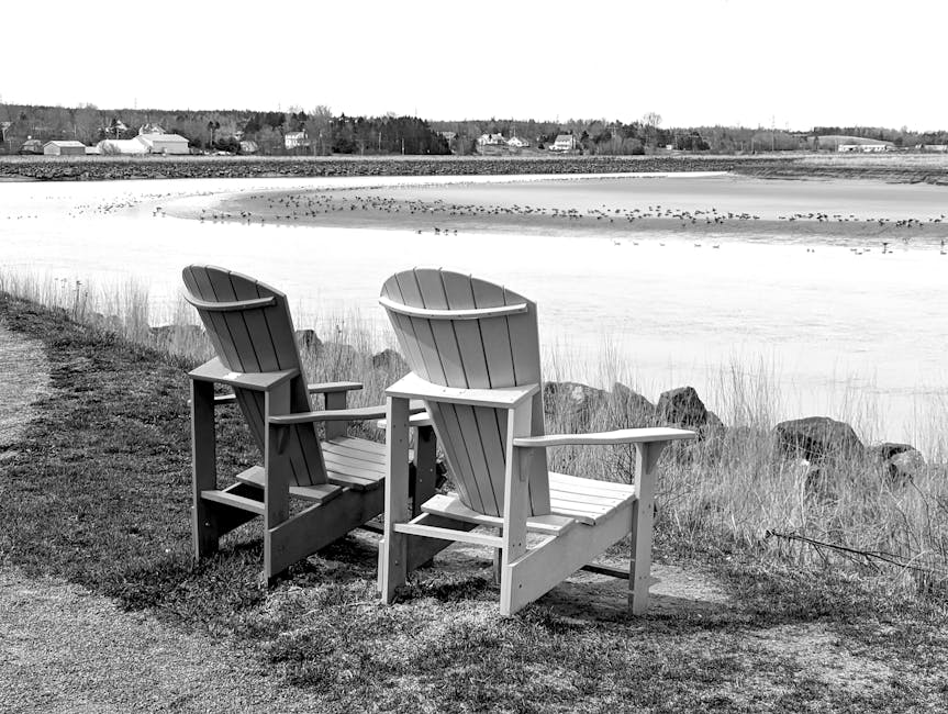 Peaceful riverfront scene with wooden chairs overlooking water in Truro, Nova Scotia.