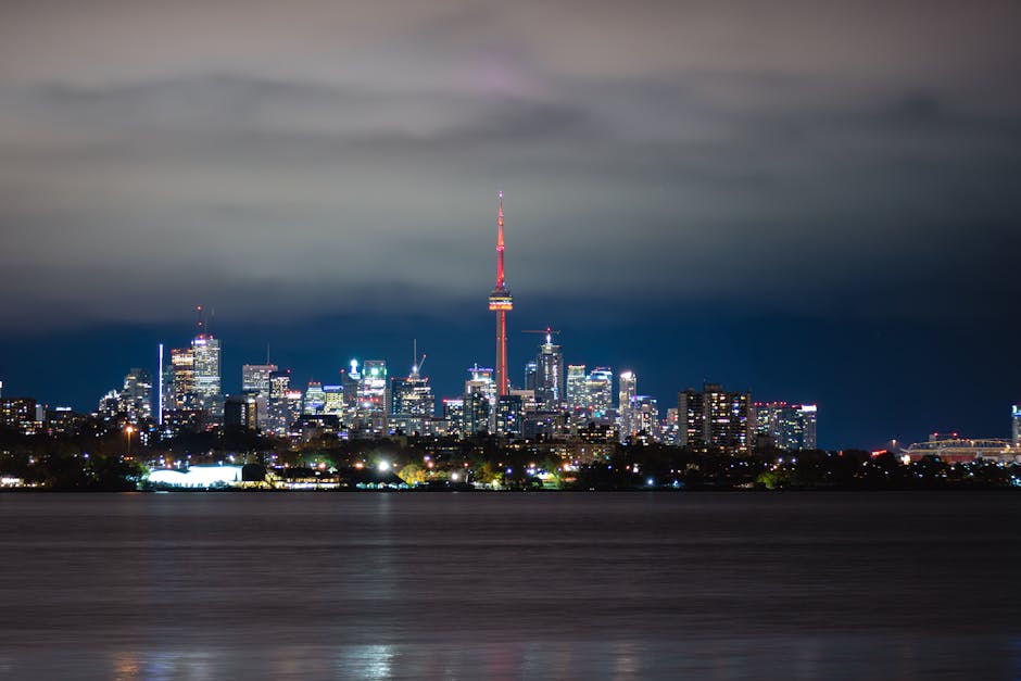 Breathtaking night view of Toronto cityscape with the iconic CN Tower glowing amidst the skyscrapers.