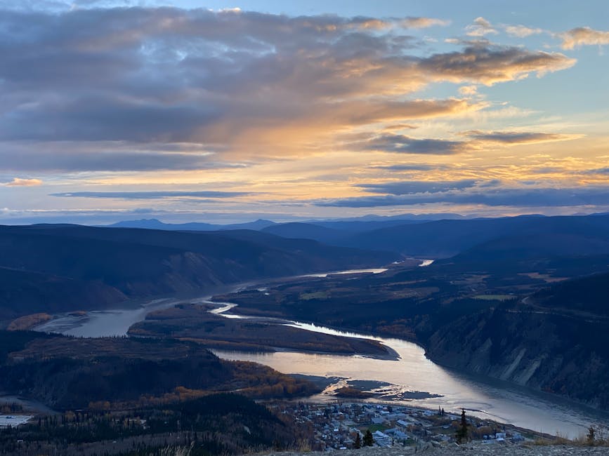 A breathtaking aerial shot of the Yukon River winding through mountains at sunset, showcasing stunning natural beauty.